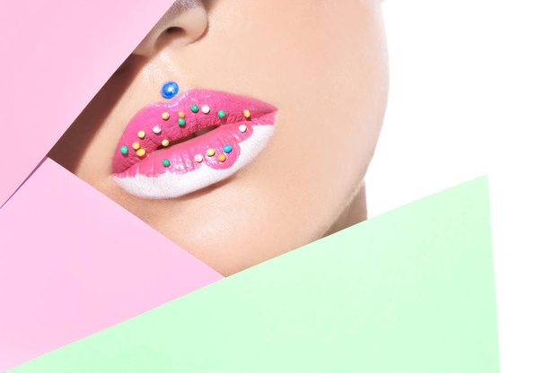 Beautiful young model with creative lips makeup and paper on white background - Фото, зображення