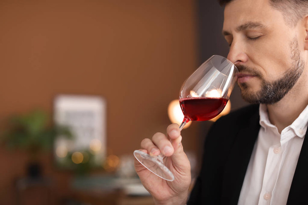 Young man with glass of wine indoors - Foto, Imagem