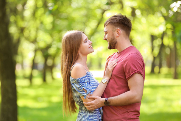 Happy young couple in green park on sunny spring day - Fotografie, Obrázek