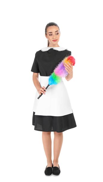 Young chambermaid with dusting brush on white background - Foto, afbeelding