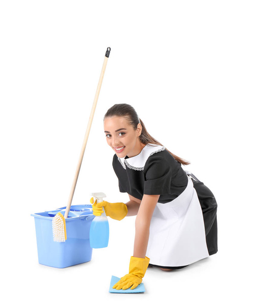 Young chambermaid with cleaning supplies on white background - Foto, afbeelding