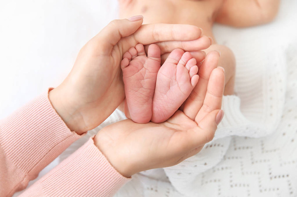 Mother holding little baby feet in hands - Φωτογραφία, εικόνα