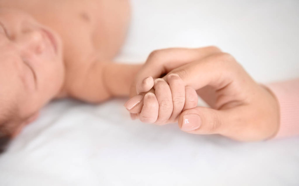 Mother holding little baby hand - Φωτογραφία, εικόνα