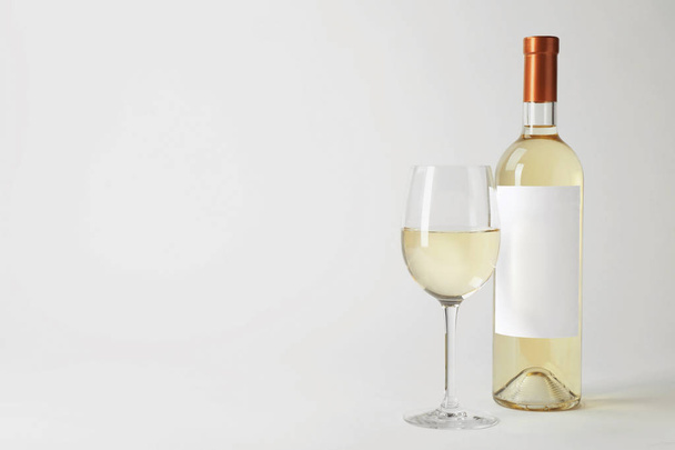 ボトルとグラスに白い背景の上のおいしいワイン - 写真・画像