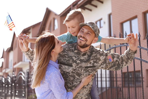 Male soldier reunited with his family outdoors. Military service - Zdjęcie, obraz