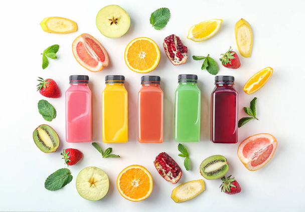 Flat lay composition with tasty juices and ingredients on light background - 写真・画像