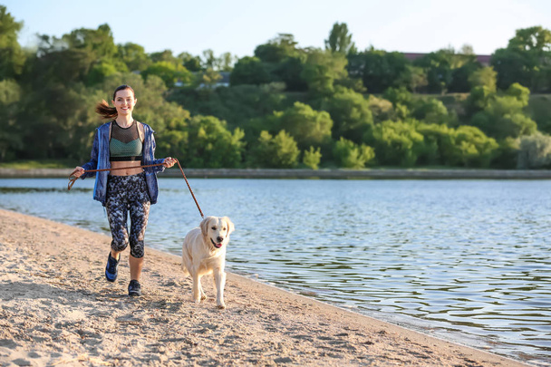 Young woman with her dog together on beach. Pet care - Valokuva, kuva