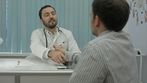 Male bearded doctor in clinic with male patient shake hands - Fotografie, Obrázek