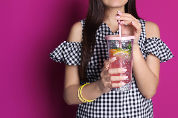 Young woman with tasty lemonade on color background. Natural detox drink - Fotó, kép