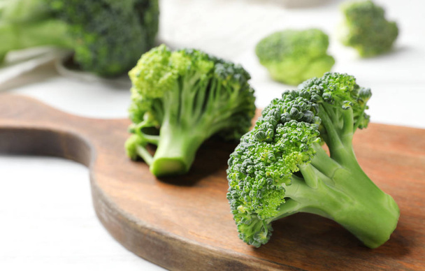 Board with fresh green broccoli on table, closeup - Photo, image