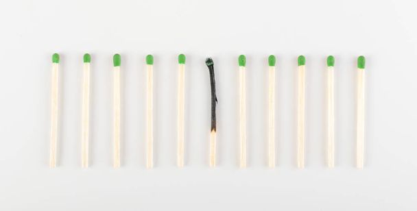 One Burned Match among Many Unburned Ones. Group of Match Sticks or Safety Matches. Individuality and Difference Concept - Photo, Image