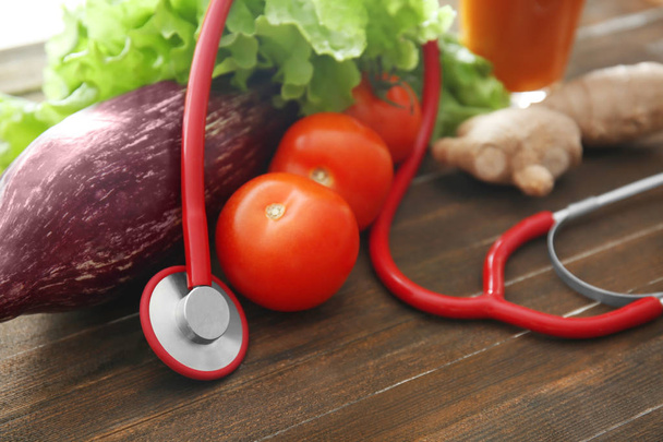 Stetoskop ile sebze ahşap masa üzerinde. Sağlıklı gıda kavramı - Fotoğraf, Görsel