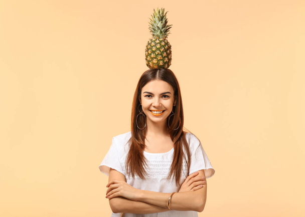 Attractive young woman with pineapple on color background - Photo, Image