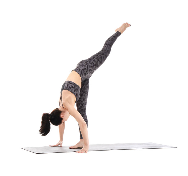Beyaz arka planda yoga yapan genç bir kadın. - Fotoğraf, Görsel