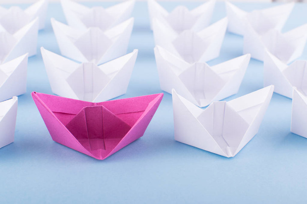 One Unique Pink Paper Boat among Many Ones. Different Paper Ships as Individuality and Leadership Concept - 写真・画像