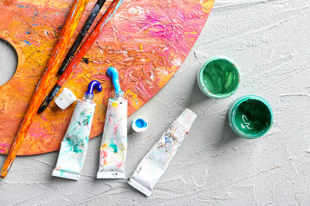 Frascos e tubos de tintas com pincéis e paleta na mesa
 - Foto, Imagem
