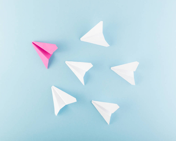 Un plano de papel rosa único entre muchos. Diferentes aviones de papel como concepto de individualidad y liderazgo
 - Foto, imagen