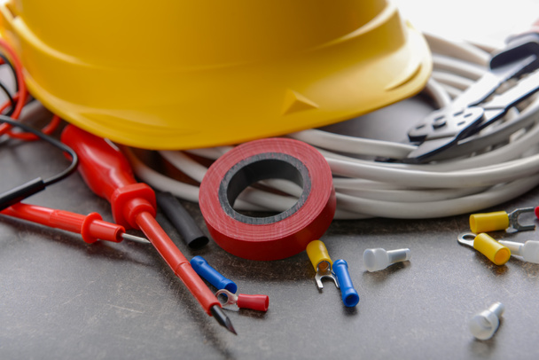 Electrician's supplies with hard hat on grey background - Photo, Image