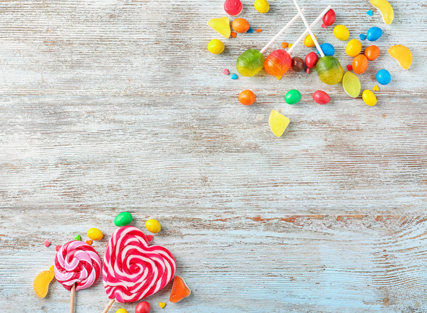 Различные красочные конфеты на деревянном фоне
 - Фото, изображение