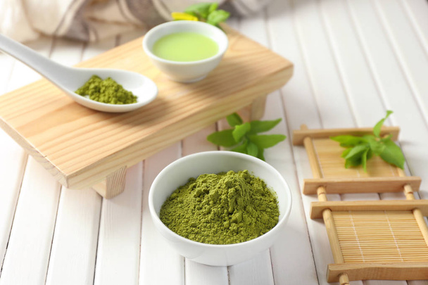Bowl with powdered matcha green tea on table - Photo, image