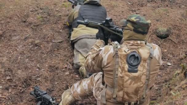 Soldaten in camouflage met bestrijding wapens zijn ontslagen in de beschutting van het bos, het militaire concept - Video