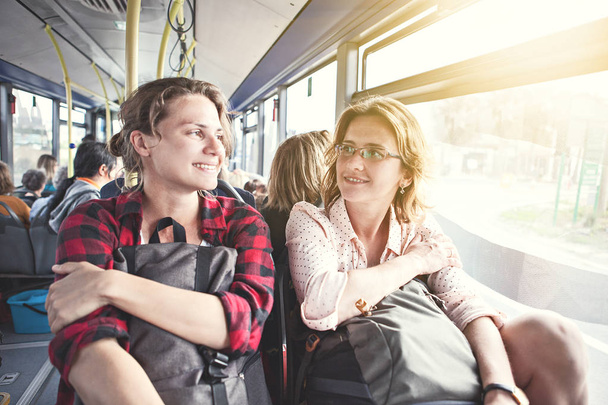 Two girls travel with backpacks by bus, public transport, travel and vacation, friendship - Valokuva, kuva