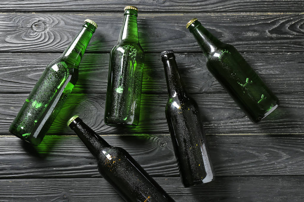 Fresh beer in glass bottles on wooden background - Foto, afbeelding