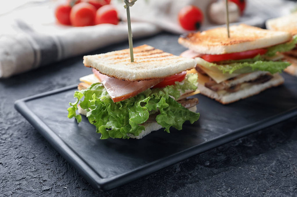 Plate with tasty sandwiches on textured table - 写真・画像