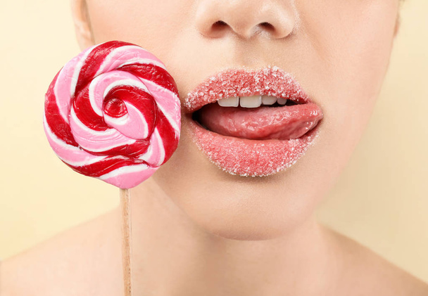 Beautiful young woman with creative makeup and lollipop on color background, closeup - Valokuva, kuva