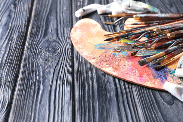 Paleta de pintura con suministros en mesa de madera
 - Foto, imagen
