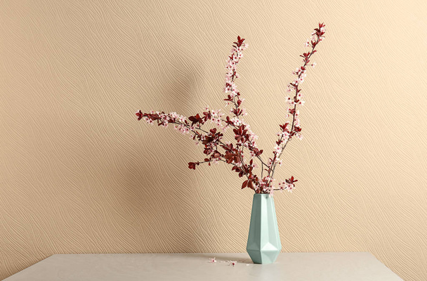 Vase with beautiful blossoming branches on table - Foto, imagen