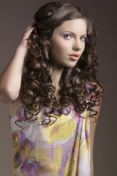 красива брюнетка з рукою в кучеряве волосся
 - Фото, зображення