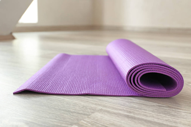 Yoga mat on wooden floor - Foto, imagen