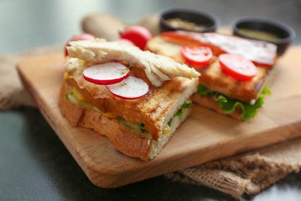 Поджаренный хлеб с овощами на деревянной доске, крупным планом
 - Фото, изображение