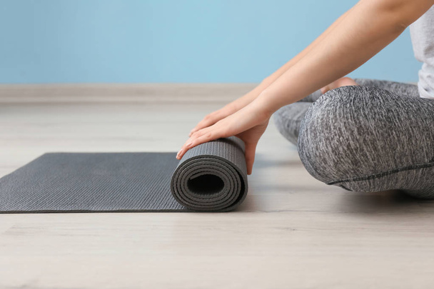 Young woman with yoga mat indoors - Foto, Imagen