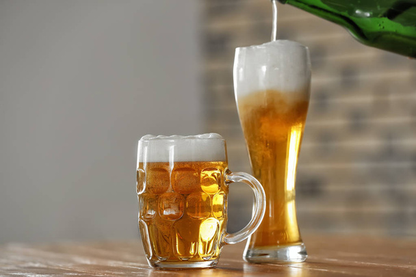 Glasses with beer on table in bar - Фото, изображение