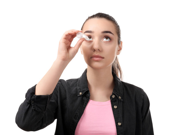 Νεαρή γυναίκα χρησιμοποιώντας το μάτι πέφτει σε άσπρο φόντο. Αλλεργία έννοια - Φωτογραφία, εικόνα