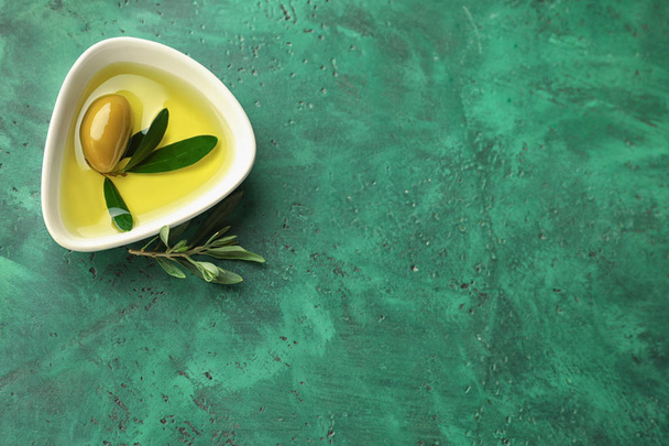 Kom met verse olijfolie op tafel - Foto, afbeelding