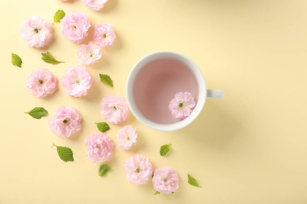 Композиція з чашкою і квітами на кольоровому фоні
 - Фото, зображення