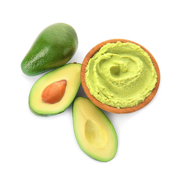 Bowl with tasty guacamole and ripe avocados on white background - Photo, Image