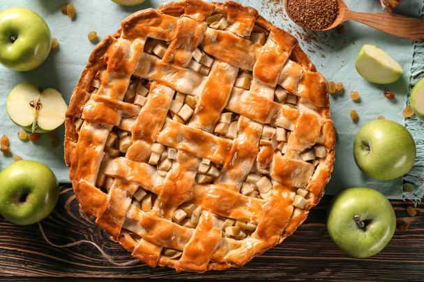 Composición con delicioso pastel de manzana en mesa de madera
 - Foto, Imagen