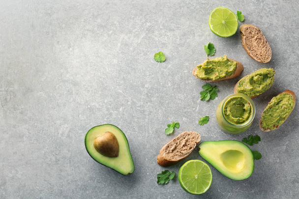 Sliced bread with delicious guacamole, lime and avocado on table - Photo, Image