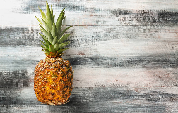 Delicious pineapple on wooden background - Фото, изображение