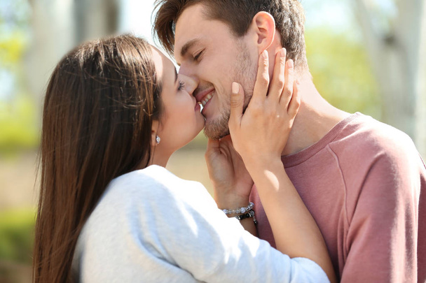 Joven pareja encantadora besándose al aire libre
 - Foto, Imagen