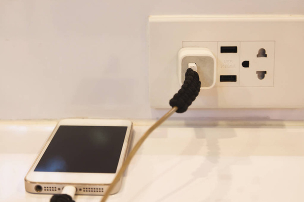 Электрическая розетка с подключенным зарядным устройством
 - Фото, изображение