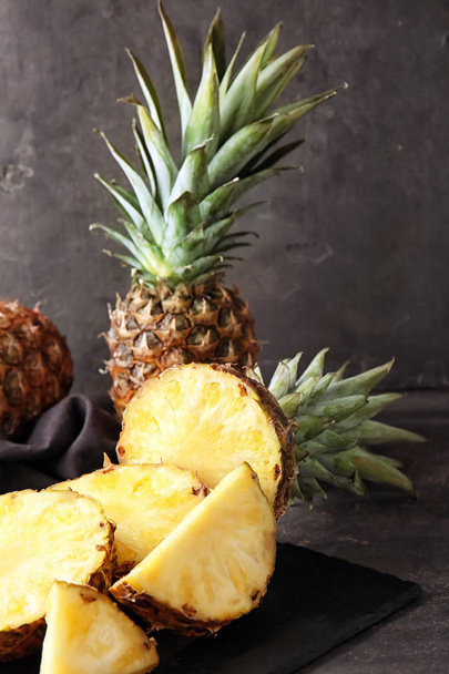 Slate plate with delicious cut pineapples on table - Φωτογραφία, εικόνα