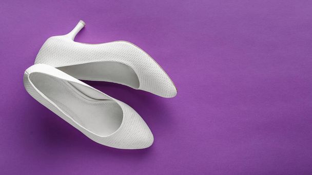 Простые белые свадебные туфли на фиолетовом фоне
 - Фото, изображение
