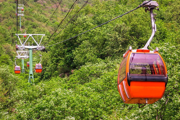 Cabine de couleur orange à téléphérique sur fond de paysage montagnard
 - Photo, image