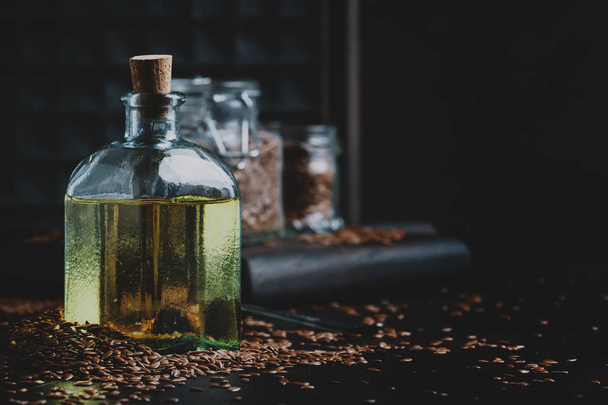 Linen or flax cold pressed oil in bottle, rustic style, vintage background, selective focus - Foto, Imagen