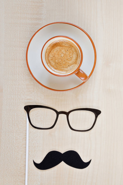 Mustache, glasses and cup of coffee on wooden background. Happy Father's day background. Copy space for inscription. Greeting card - Zdjęcie, obraz
